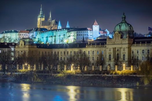 Charles bridge and Vltava river at night with blurred boat movement, Prague, Czech Republic