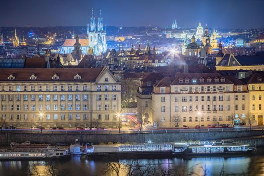 Above Prague old town, boats and river Vltava at dramatic night, Czech Republic
