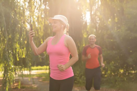 a woman and a man go in for sports in the forest.
