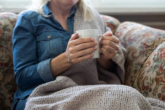 warm cup of hot coffee warming in the hands of a girl