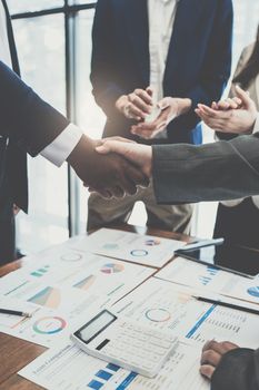 Successful businessmen handshaking after good deal at meeting room.