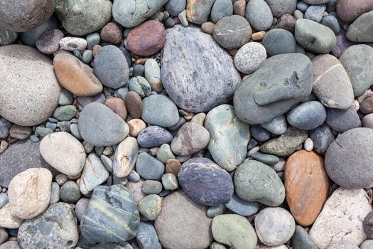 Large stones of different shapes on the riverbank close-up. there are a lot of small stones nearby.