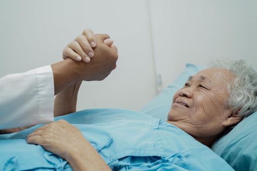 Doctor holding hands Asian elderly woman patient, help and care in hospital.
