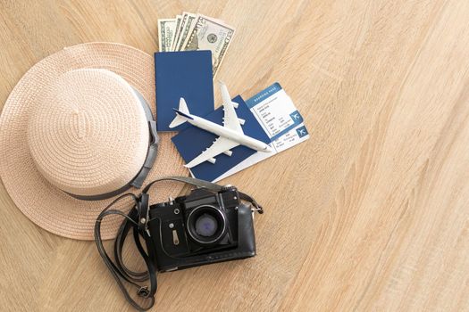 Flat lay composition with passport, toy plane and camera on wooden background, space for text. Visa receiving.