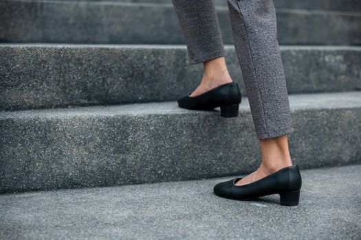 Stepping going up stairs in city, Closeup legs of businesswoman hurry up walking on stairway, rush hour to work in office a hurry in morning, foot of business woman wear black shoes step up success