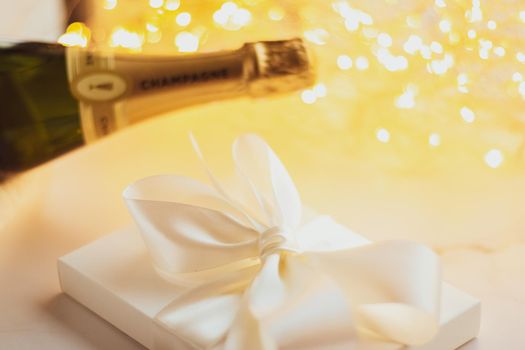 Romantic celebration, lifestyle and luxury present concept - The bottle of champagne and holiday gift box