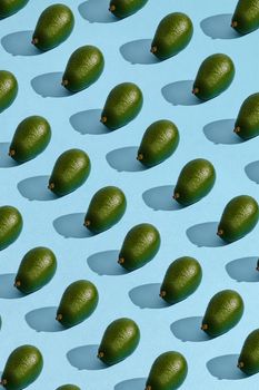 Food design. Colorful fruit pattern of fresh whole avocado arranged on blue pastel background. Mock up, flat lay style