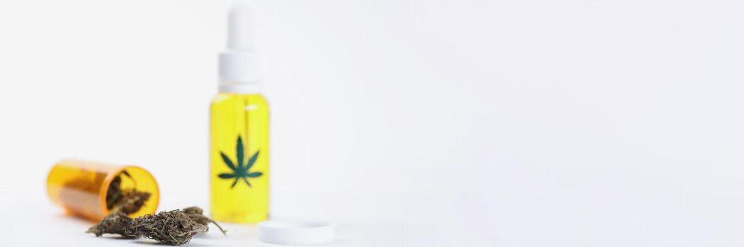 Closeup of marijuana oil in bottles and dried hemp leaves on white background. Legalization of production of narcotic drugs concept