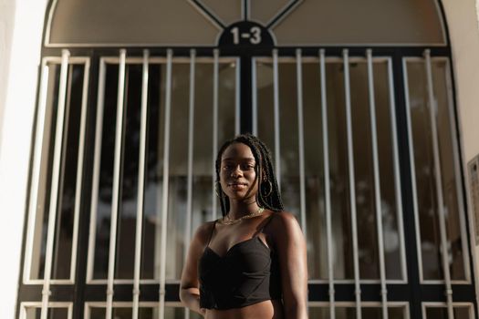 Portrait of a young black female posing in front of a doorway during a modeling session at sunset