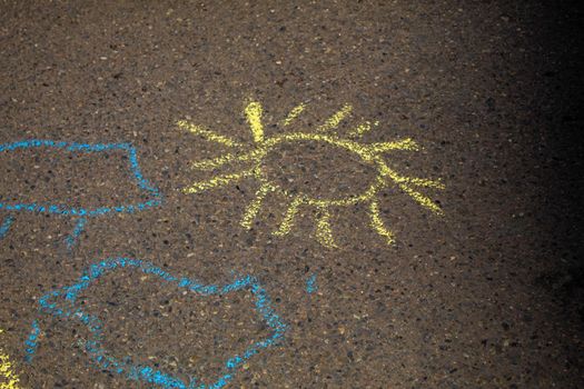 Children paint a rainbow on the asphalt. Selective focus. Kids.