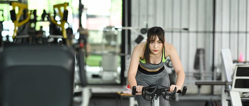 Fitness woman in sportswear workout cycling bikes in the gym.