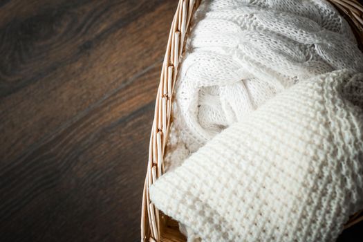 Knitwear, fabric textures and rustic lifestyle concept - Knitted winter clothes in a basket