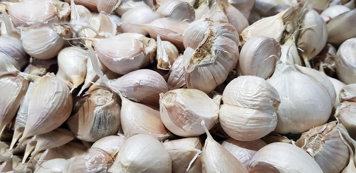 Garlic bulbs on black background, close-up. Organic garlic top view. Food background. Selective focus.