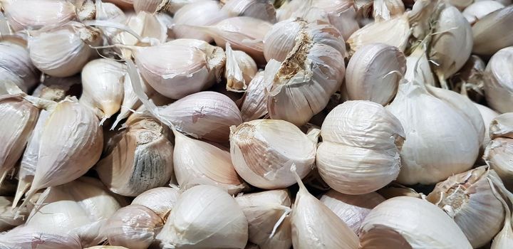 Garlic bulbs on black background, close-up. Organic garlic top view. Food background. Selective focus.