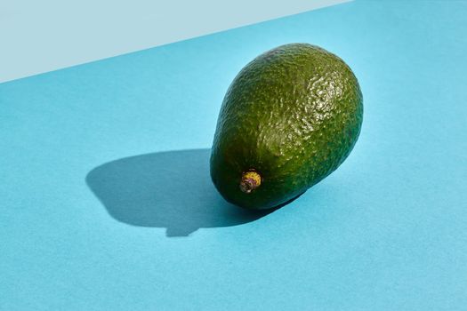 Close up high quality image of whole avocado, fruit composition on blue background. Mockup, flat style