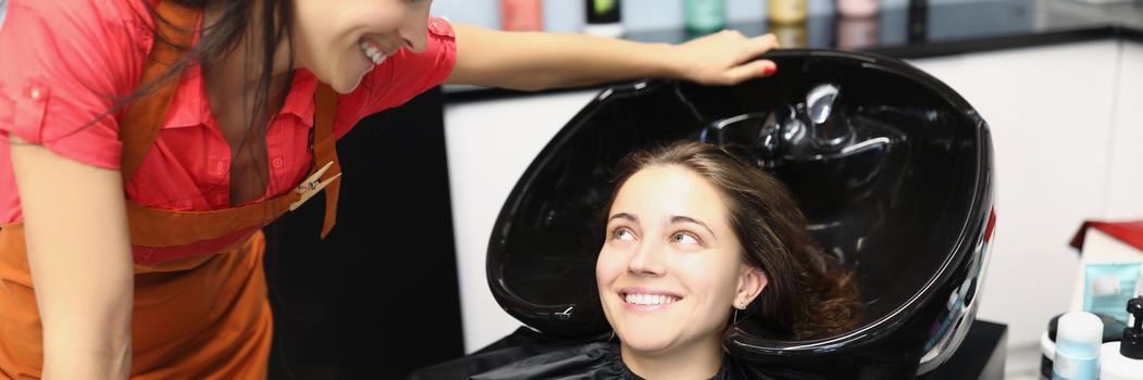 Woman hairdresser communicating with client near hair wash. Hair care concept