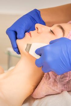 Beautiful young woman receiving ultrasonic cavitation facial cleansing in beauty spa salon