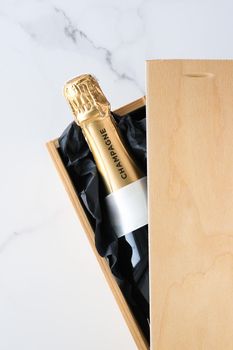 Wedding celebration, lifestyle and luxury present concept - A champagne bottle and a gift box on marble