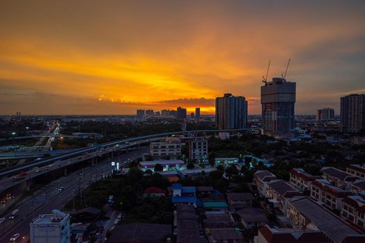 Bangkok, Thailand - August 24, 2022: Scenic aerial view of twilight cityscape in downtown Bangkok. Bangkok downtown in a night scene with villages, high-rise residents, construction sites, and gas stations as background.