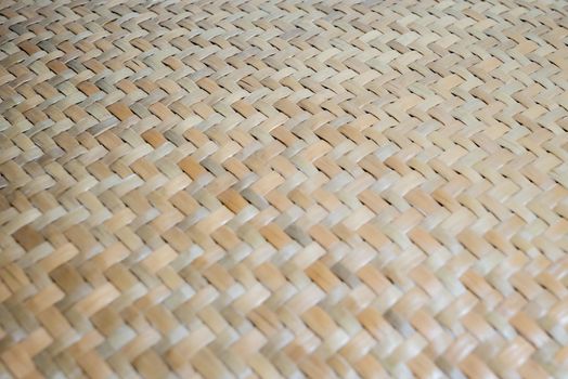 A specific focused point of abstract wicker texture of bamboo weaver which made of pieces of bamboo tiles weaved together. Bamboo wicker basket texture.