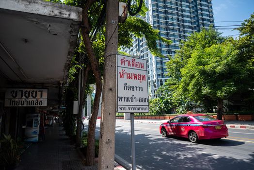 Bangkok, Thailand - August 24, 2022: Taksin, Bangkok cityscape, Drug stores in the urban area and traffic label noticed that "Do not stop blocking the entrance and exit".