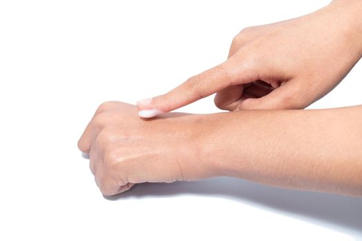 Closeup woman applying protective cream on hands. Cold season and dry air, applying lotion for preventing dry skin. Isolation in white background with clipping path.