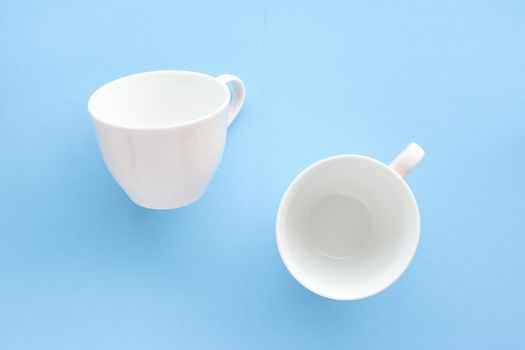 Kitchen, dishware and drinks concept - Empty cup and saucer on blue background, flatlay