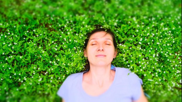 top view portrait of a pretty young woman relaxing on a grass download photo