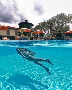 Attractive young womanl swims underwater.Woman swimming underwater in pool. download photo