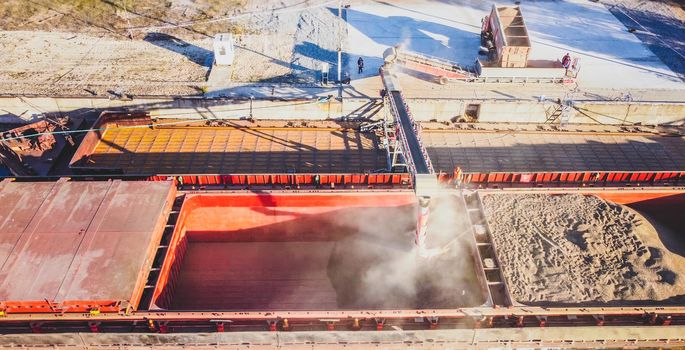 Russians loading grain into holds of sea cargo vessel through an automatic line in seaport from ukranian grain storage. download photo