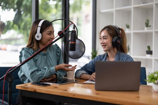 two asian radio podcasters recording interview each other for radio podcast