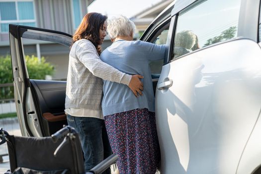Caregiver help Asian senior or elderly old lady woman patient get to her car, healthy strong medical concept.
