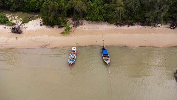 Many fishing boats near the seashore in tropical islands. Pier of the villagers on the southern island of Thailand. top view from drones.