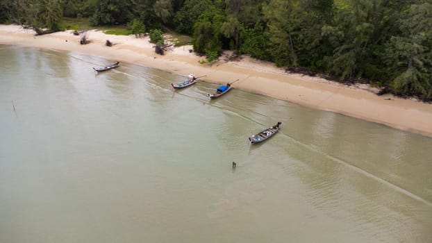 Many fishing boats near the seashore in tropical islands. Pier of the villagers on the southern island of Thailand. top view from drones.