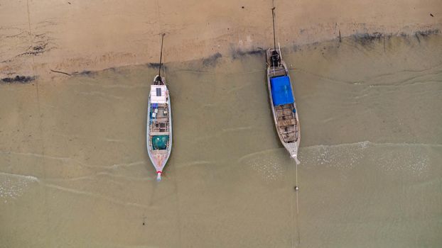 Many fishing boats near the seashore in tropical islands. Pier of the villagers on the southern island of Thailand. top view from drones.