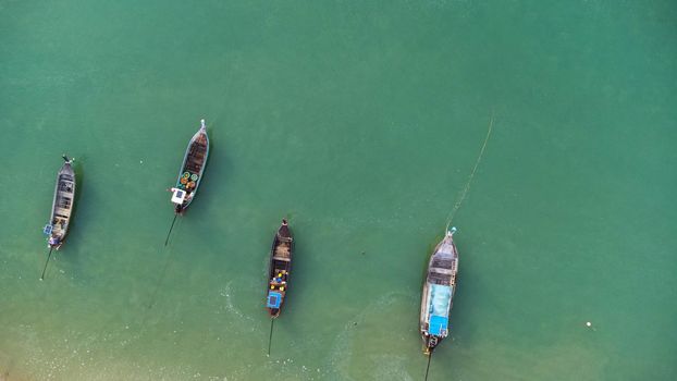 Many fishing boats near the seashore in tropical islands. Pier of the villagers on the southern island of Thailand. top view from drones.