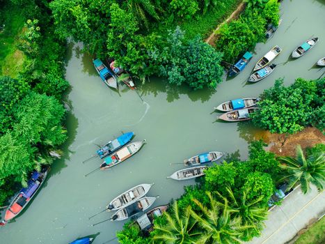 Aerial view from drones of fisherman boats and harbour in the river near the Andaman Sea in southern Thailand. Top view of many Thai traditional longtail boats floating in the mangrove landscape.