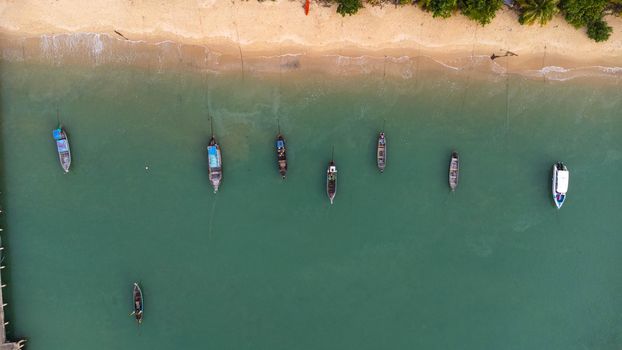 Many fishing boats near the seashore in tropical islands. Pier of the villagers on the southern island of Thailand. top view from drones.