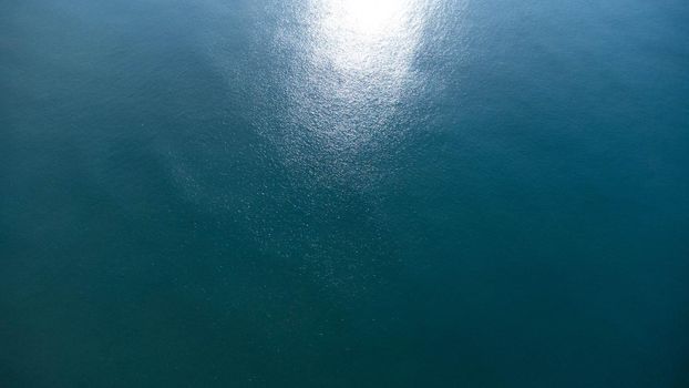 Aerial view from the drone of the sea. Background image of sea surface with sunlight reflecting on water surface. blue sea background in tropical sea