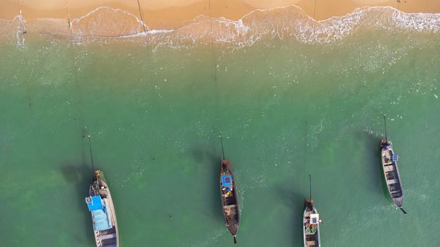 Many fishing boats near the seashore in tropical islands. Pier of the villagers on the southern island of Thailand. top view from drones.