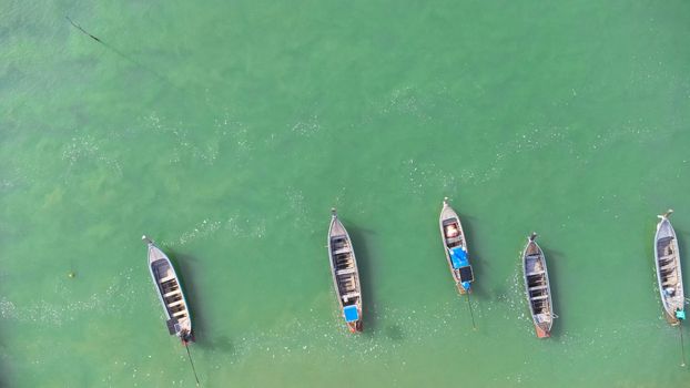 Many fishing boats near the seashore in tropical islands. Pier of the villagers on the southern island of Thailand. top view from drones.