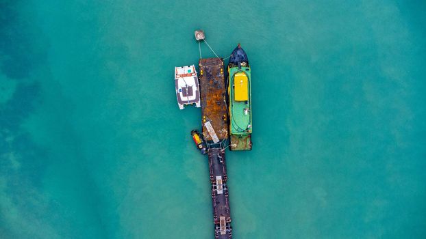 Aerial view from drone of commercial ship in the wharf. Transportation and travel background, beautiful sea in summer.