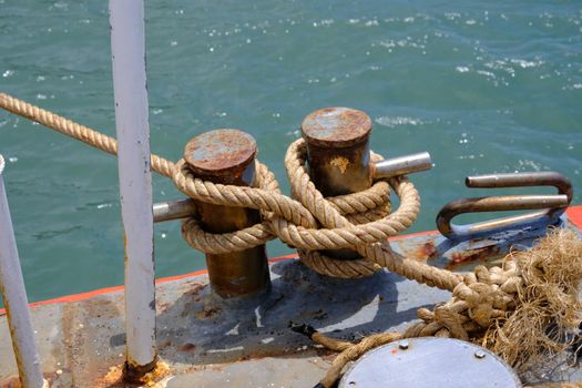 Close up of ropes and rusty bollard. rope and Marina bollard on moorage. Nautical mooring rope. The concept of mooring and water transportation