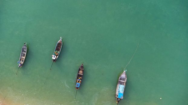 Many fishing boats near the seashore in tropical islands. Pier of the villagers on the southern island of Thailand. top view from drones.