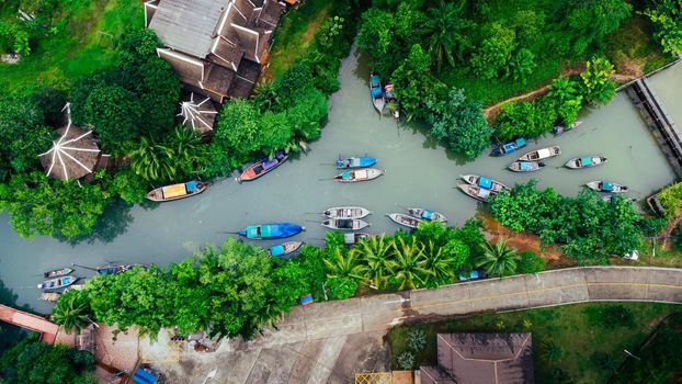 Aerial view from drones of fisherman boats and harbour in the river near the Andaman Sea in southern Thailand. Top view of many Thai traditional longtail boats floating in the mangrove landscape.