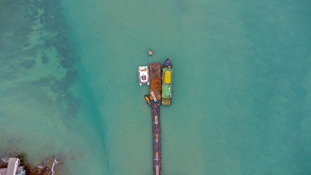 Aerial view from drone of commercial ship in the wharf. Transportation and travel background, beautiful sea in summer.