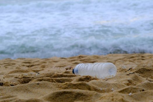 Plastic water bottle on the beach. Concept of plastic pollution and environmental problems