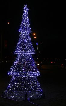 Decoration of a city festive christmas tree. Festive Christmas illumination from electric lights in the shape of a Christmas tree.