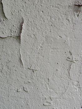 Image of old peeling gray paint on concrete wall.