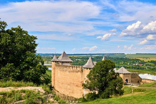 a military stronghold, especially a strongly fortified town fit for a large garrison. Old medieval fortress museum on green hills by the river